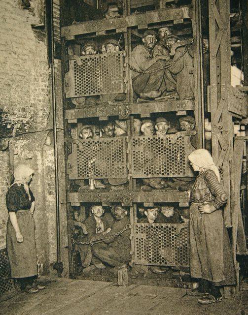 1900 Belgium coal miners crammed into a coal mine elevator, coming up after a day of work.jpg